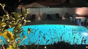 A swimming pool with lounge chairs and umbrellas, surrounded by greenery. - Guesthouse with a pool, 200 meters from the beach, air-conditioned (Roquebrune-sur-Argens)