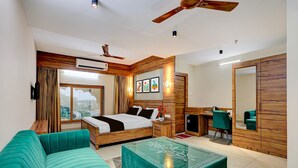 Une chambre d’hôtel moderne équipée d’un lit, d’un canapé, d’un bureau et d’un miroir.