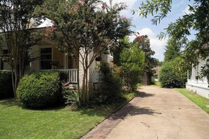 A residential street with houses, a sidewalk, and greenery. - Porch swing, 1920s home, walk to live music (Clarksdale)