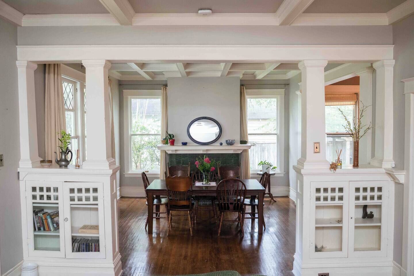 Un comedor con chimenea, sillas de madera y una mesa.