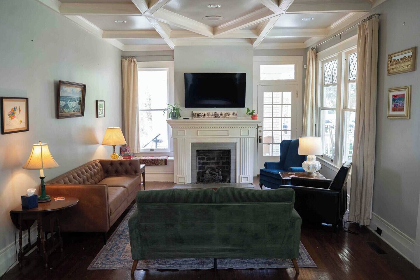 A living room with a fireplace, a television, and a green sofa.