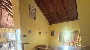 A spacious room with a long table, a staircase, and a view of the outside. -  4- bedroom/ 12 bed-Oracabessa Seaside Jamaican Manor  Private Beachfront Access (Oracabessa)