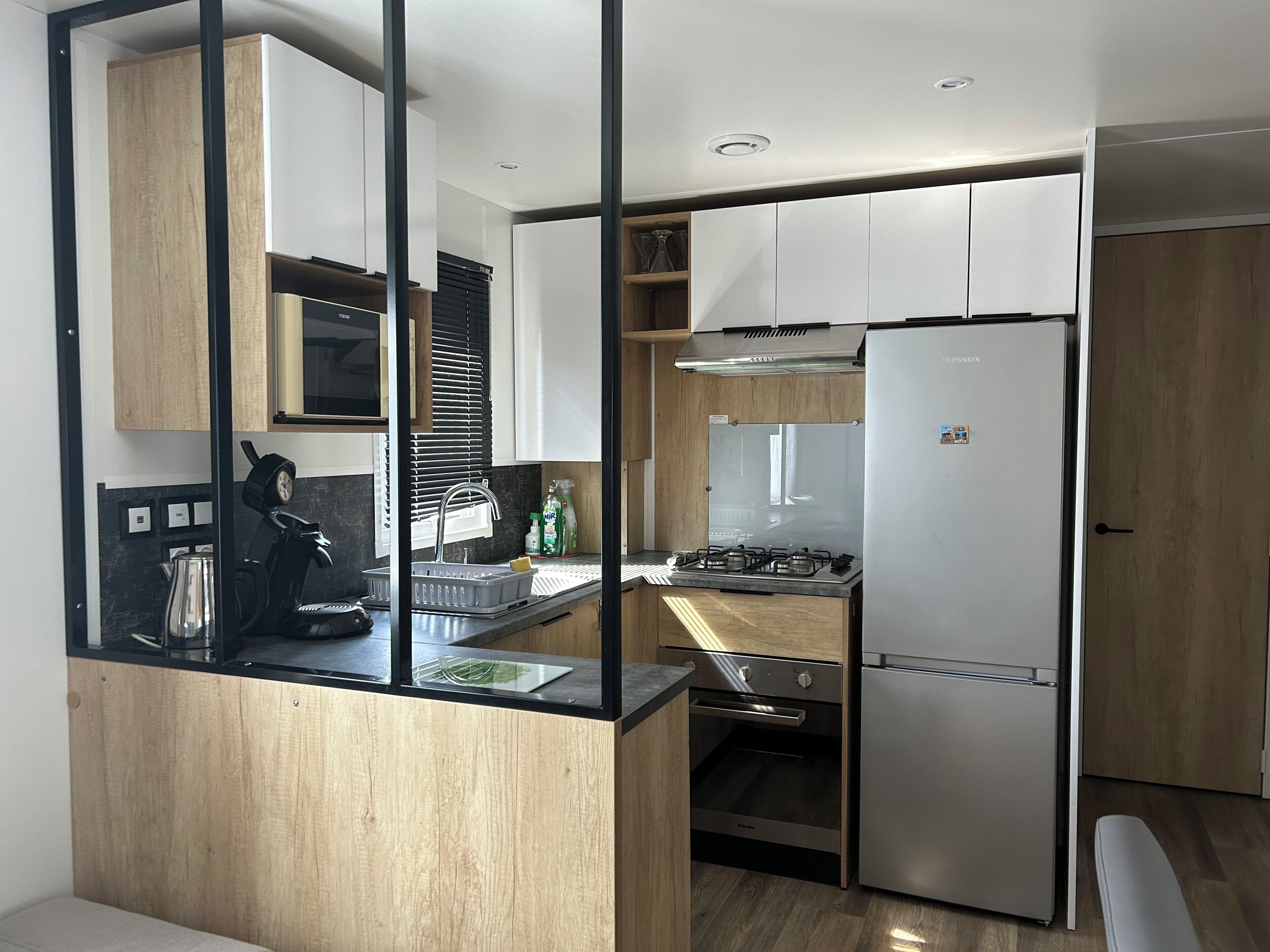 A compact kitchen with a built-in stove, a refrigerator, and a sink.
