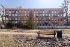 A park with a bench and a trash can. - Flat Near Koneser Center (Warsaw)