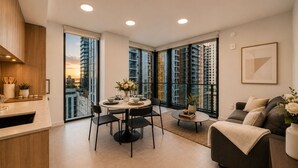 A modern living room with a dining area, large windows with city views, and a kitchen with wooden cabinetry. - Downtown Miami 1BR with City Views (Miami)
