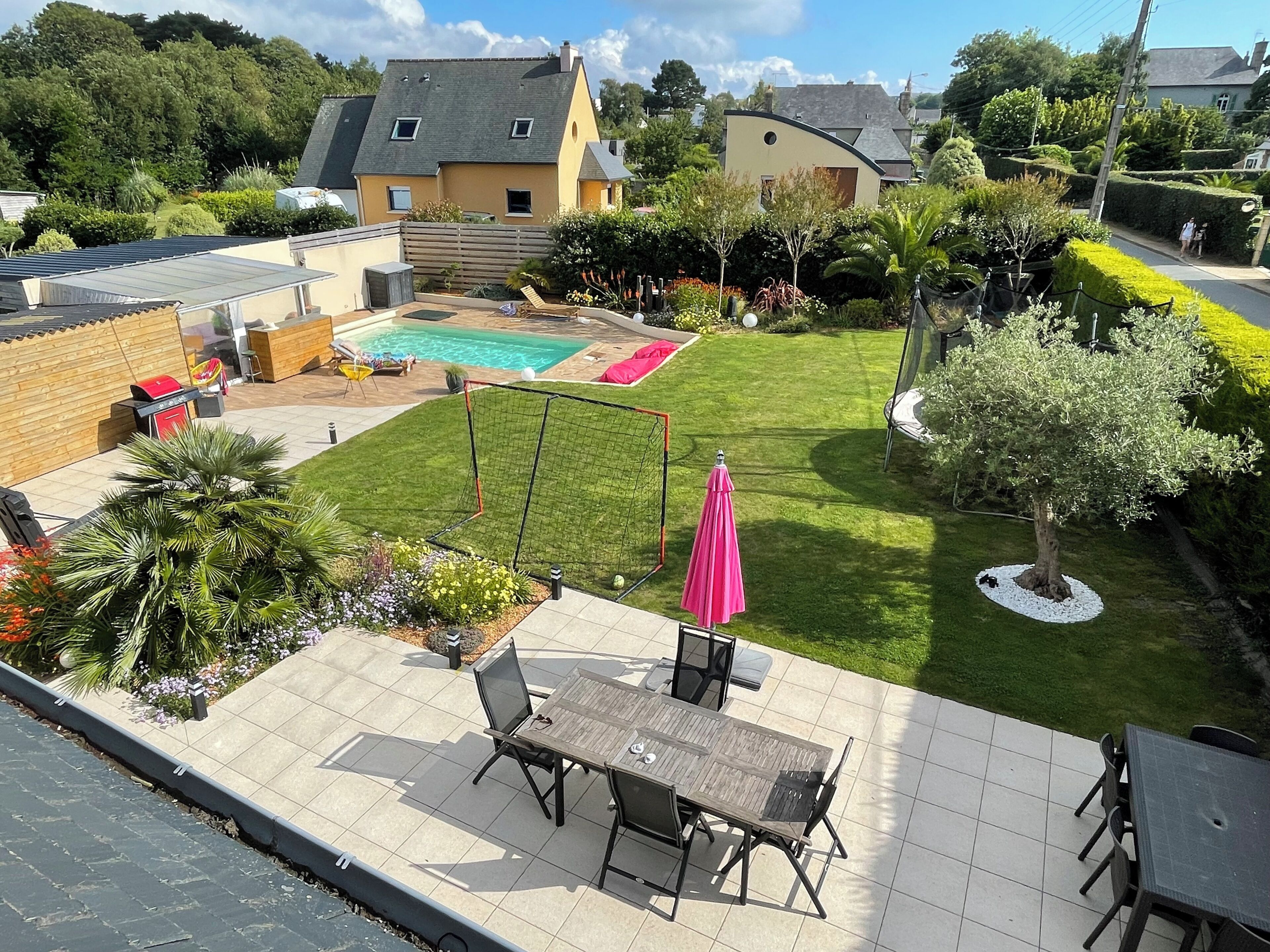 Ein gepflegter Hinterhof mit Swimmingpool, Gartenmöbeln und einem Rasen.