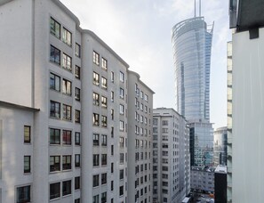 A multi-story building with a modern architectural design, featuring a mix of window styles and a prominent glass facade. - Flat Near Metro, Warsaw (Warsaw)
