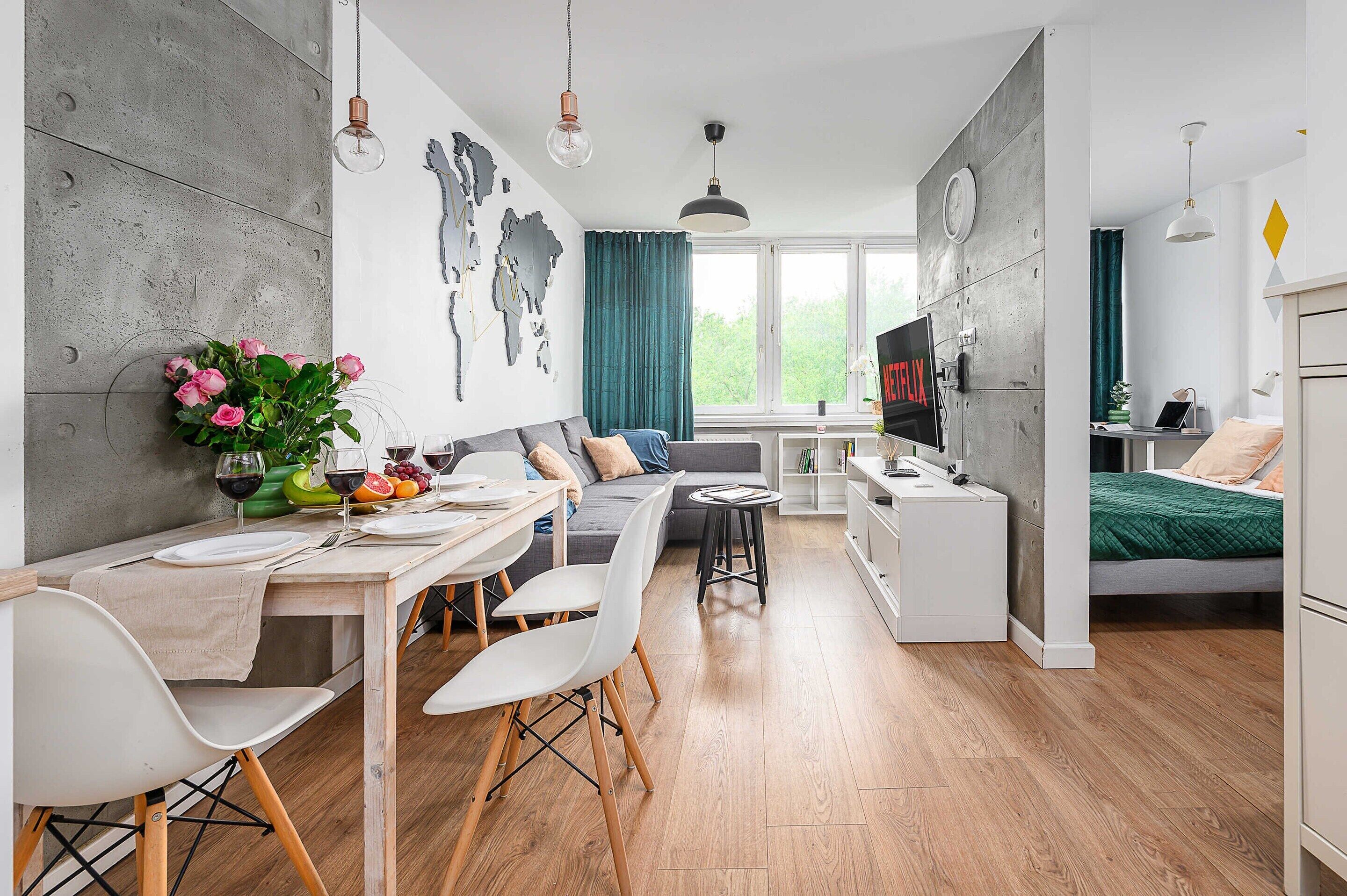 A modern apartment with a dining area, kitchen, and living space.