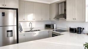 A modern kitchen with stainless steel appliances, a built-in oven, and a microwave.