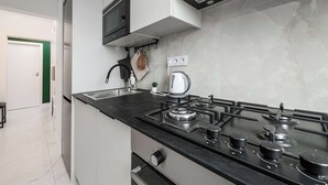 A modern kitchen with a gas stove, a built-in oven, and a microwave. - Warsaw Stay Near Cinema (Warsaw)