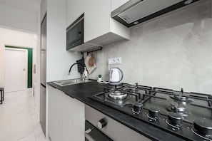 A modern kitchen with a gas stove, a built-in oven, and a microwave. - Warsaw Stay Near Cinema (Warsaw)