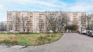 A multi-story residential building with a paved pathway leading to a parking area. - Warsaw Stay Near Cinema (Warsaw)