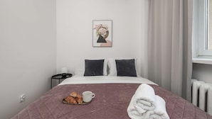 A hotel room with a bed, a nightstand, a framed picture on the wall, and a window with curtains. - Warsaw Stay Near Cinema (Warsaw)