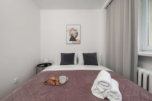 A hotel room with a bed, a nightstand, a framed picture on the wall, and a window with curtains. - Warsaw Stay Near Cinema (Warsaw)