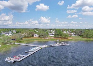 A marina with boats docked, a pier extending into the water, and a residential area in the background. - Cozy 1-bd/1-bth roof over with added Florida room and screen porch in Lake Wales (Lake Wales)