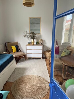 A room with a bed, a dresser, a chair, a small table, a hanging plant, and a window. - Beautiful beach beach house in Mimizan, just minutes from the ocean. (Mimizan)
