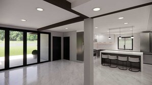 A modern kitchen with a large island, bar stools, and a view of a green landscape through large windows. - Charming 5-bedroom house with AC in Tower Isle (Tower Isle)