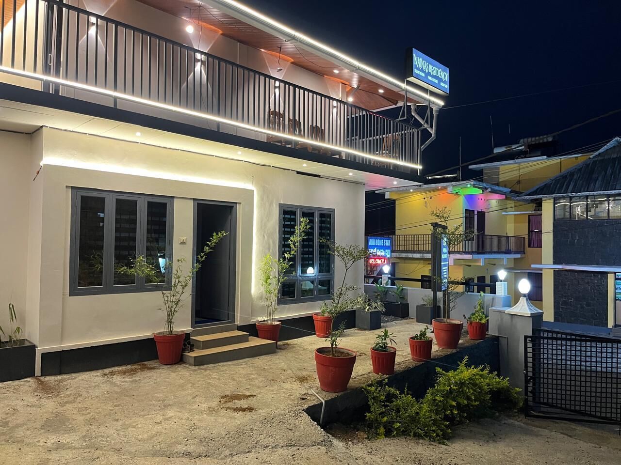 Un hotel con balcón, plantas en macetas y un cartel que indica que es una residencia.