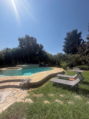 A swimming pool with a stone deck and lounge chairs. - Appartment disponible au rez de jardin d une villa privée, piscine/ barbecue (Vallauris)
