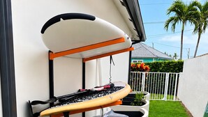 A surfboard rack and a sign indicating availability for rent at $30/day. - Sunny Cove Retreat: Walk to Beach, Dining & Marina (Deerfield Beach)