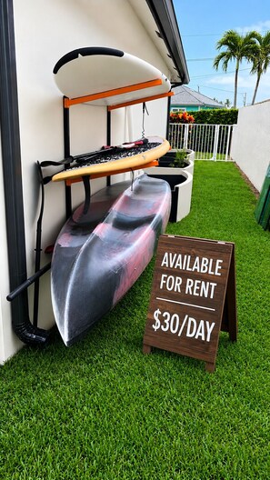 Een surfboardrek en een bord met huurprijzen: 30 dollar per dag.