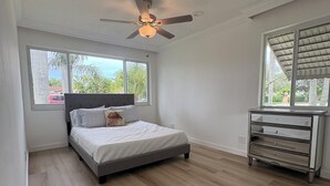 A bedroom with a bed, a ceiling fan, a window, and a dresser. - Sunny Cove Retreat: Walk to Beach, Dining & Marina (Deerfield Beach)