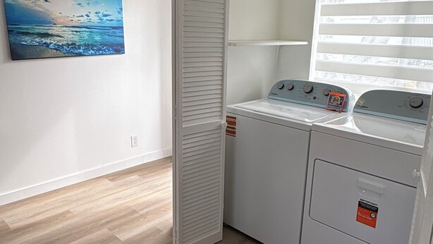 A laundry room with a washing machine, a drying rack, and a window with blinds. - Sunny Cove Retreat: Walk to Beach, Dining & Marina (Deerfield Beach)