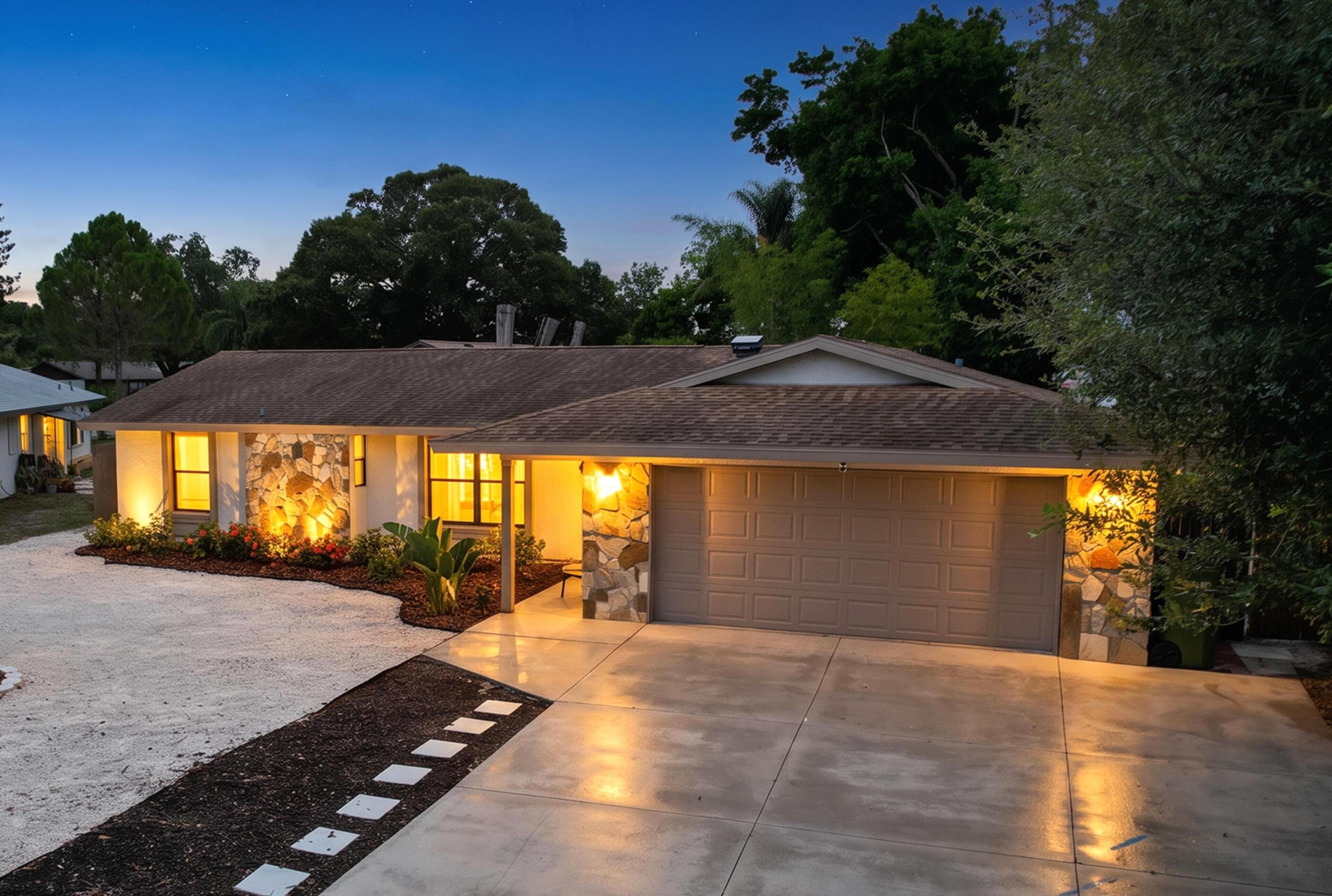 A residential house with a garage, a driveway, and a landscaped garden.