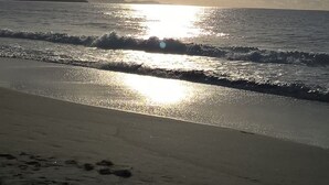 Ein Strand bei Sonnenuntergang über dem Meer, der eine friedliche Atmosphäre schafft.