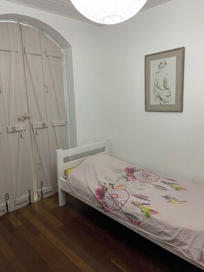 A bedroom with a single bed, a white wardrobe, and a framed artwork on the wall. - Villa Le Diamant (le diamant)