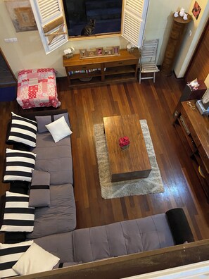 A living room with a sofa, a coffee table, and a window with shutters. - Villa Le Diamant (le diamant)