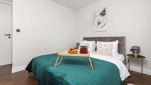 A bedroom with a bed, a bedside table with a lamp, and a wall art piece. - Family Stay in Warsaw (Warsaw)
