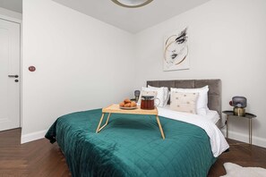 A bedroom with a bed, a bedside table with a lamp, and a wall art piece. - Family Stay in Warsaw (Warsaw)