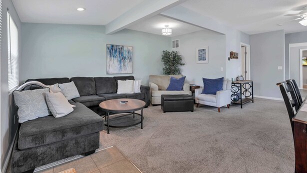 A modern living room with a sectional sofa, a round coffee table, and a small side table.