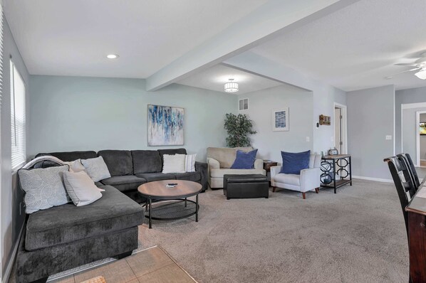 A modern living room with a sectional sofa, a round coffee table, and a small side table.