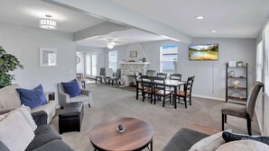 A spacious living area with a dining table, sofas, and a fireplace.
