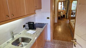 Una cocina con un lavamanos doble, armarios de madera y una encimera con cafetera.