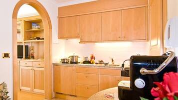 A kitchen with wooden cabinets, a microwave, and a sink.