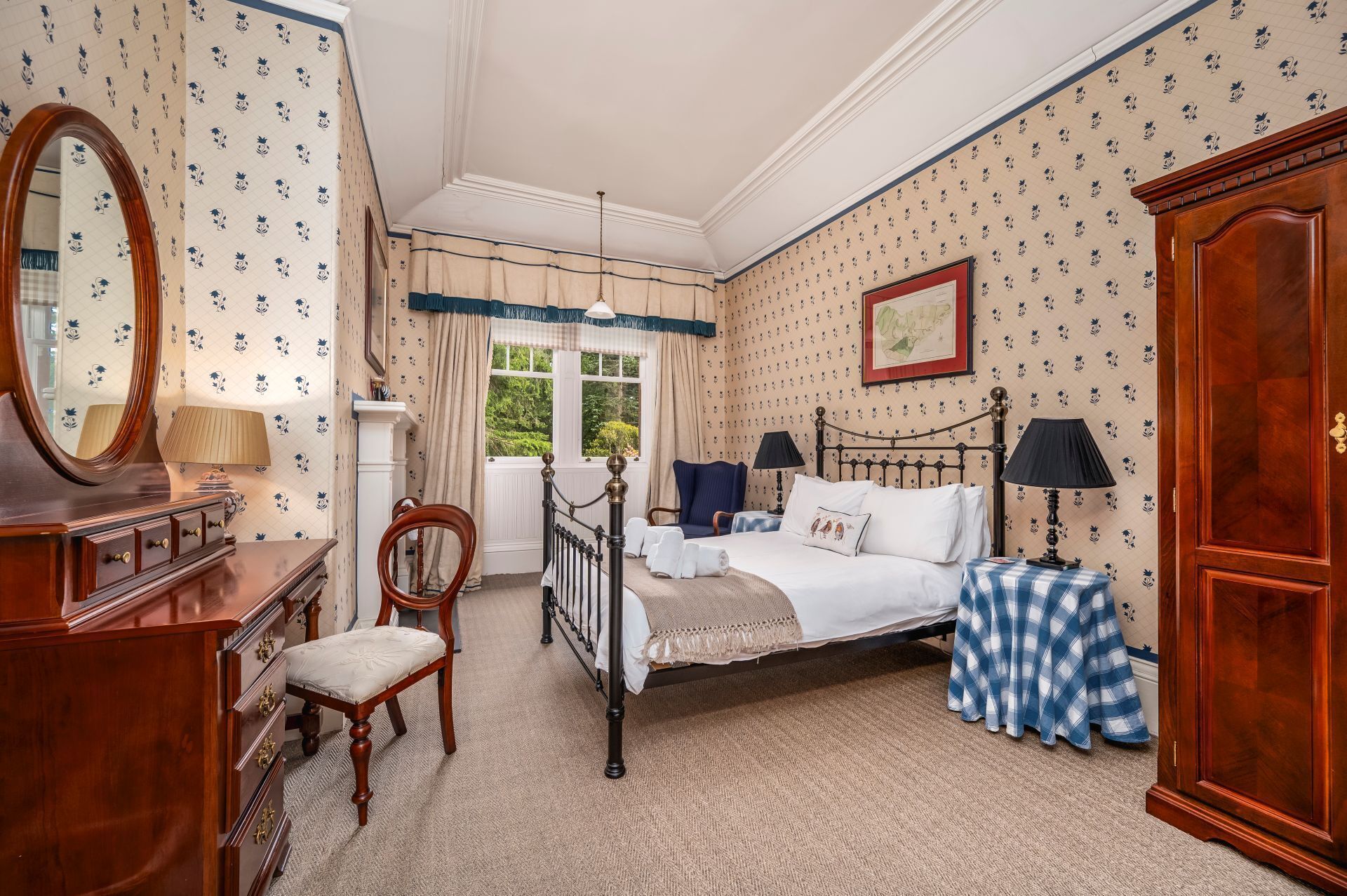 Une chambre à coucher avec un lit, une chaise, une commode, un miroir et une fenêtre avec des rideaux.