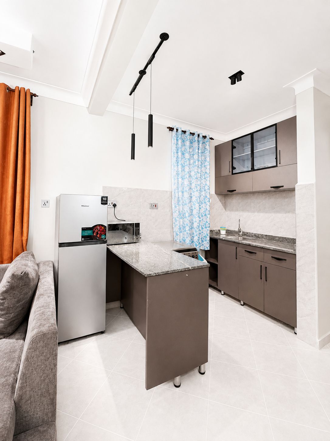 A compact kitchen with a refrigerator, microwave, and a small island.