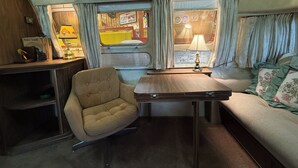 Ein gemütlicher Innenraum mit einer Couch, einem kleinen Tisch und einem Sessel.