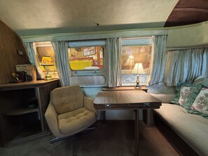 En kompakt indretning med en sofa, et lille bord og en stol.