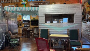 Ein rustikales Interieur im Stil eines Vintage-Dinners mit einer Dinerr-Theke, Holzstühlen und einem Neonzeichen.