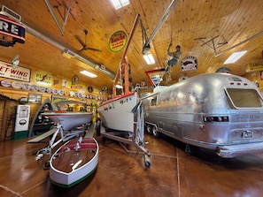 A vintage-themed room with a large vintage truck, a boat, and a camper.