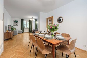 Ein Essbereich mit einem Holztisch, gedeckt für sechs Personen, umgeben von sechs Stühlen.