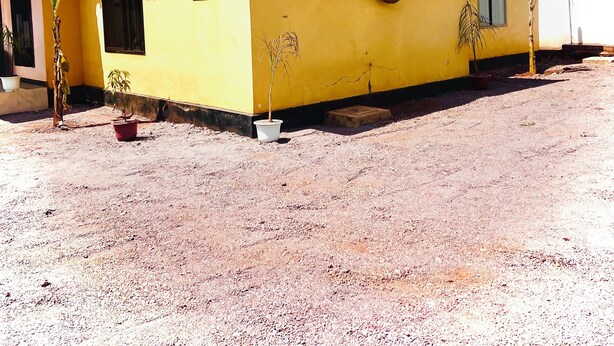 A yellow building with a red roof, a small window, and a door. - Ngorongoro Haven & Safari Stride (Karatu)