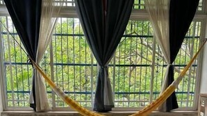 Un dormitorio con una cama, una ventana con cortinas y una hamaca.