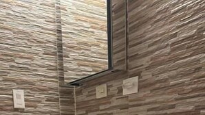 Un baño con inodoro, lavamanos y una cesta negra con toallas.