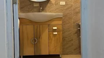 A bathroom with a wooden vanity, a sink, and a mirror.