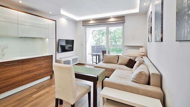 A modern living room with a sofa, TV, and dining area. - City Apartment for 6 Guests (Warsaw)